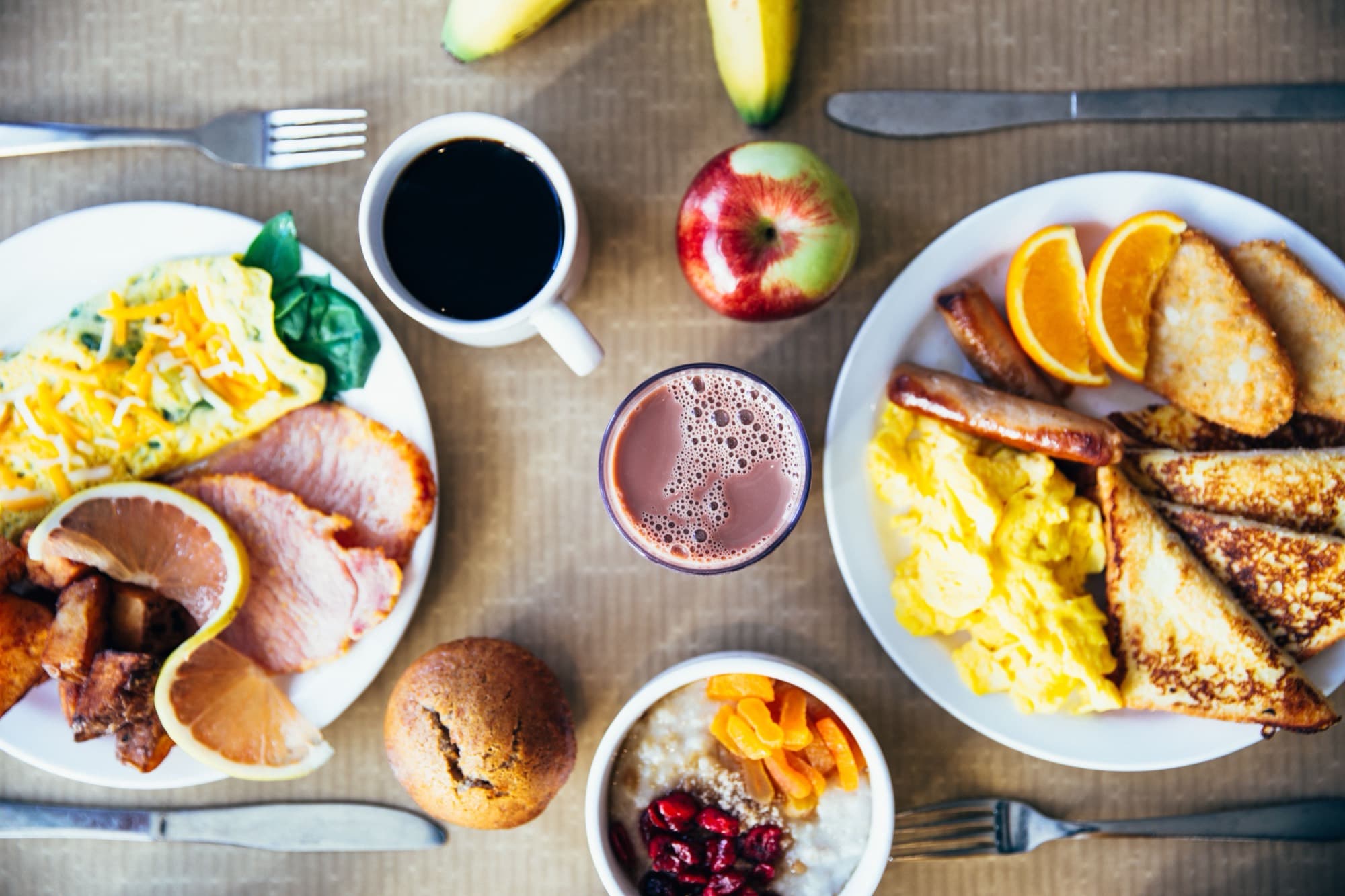 A table set with breakfast plates, coffee and fruit