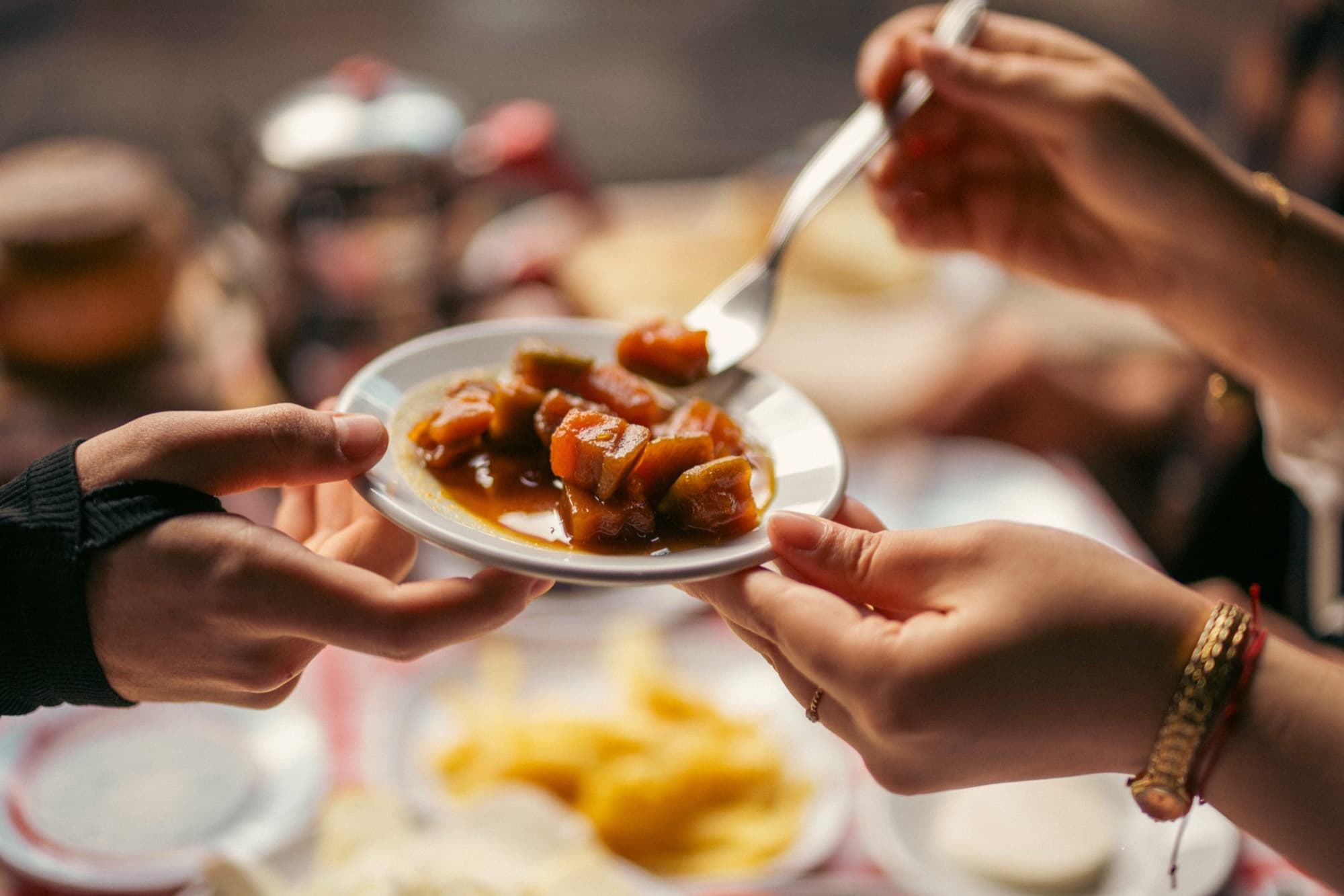 A plate of food being passed between two people